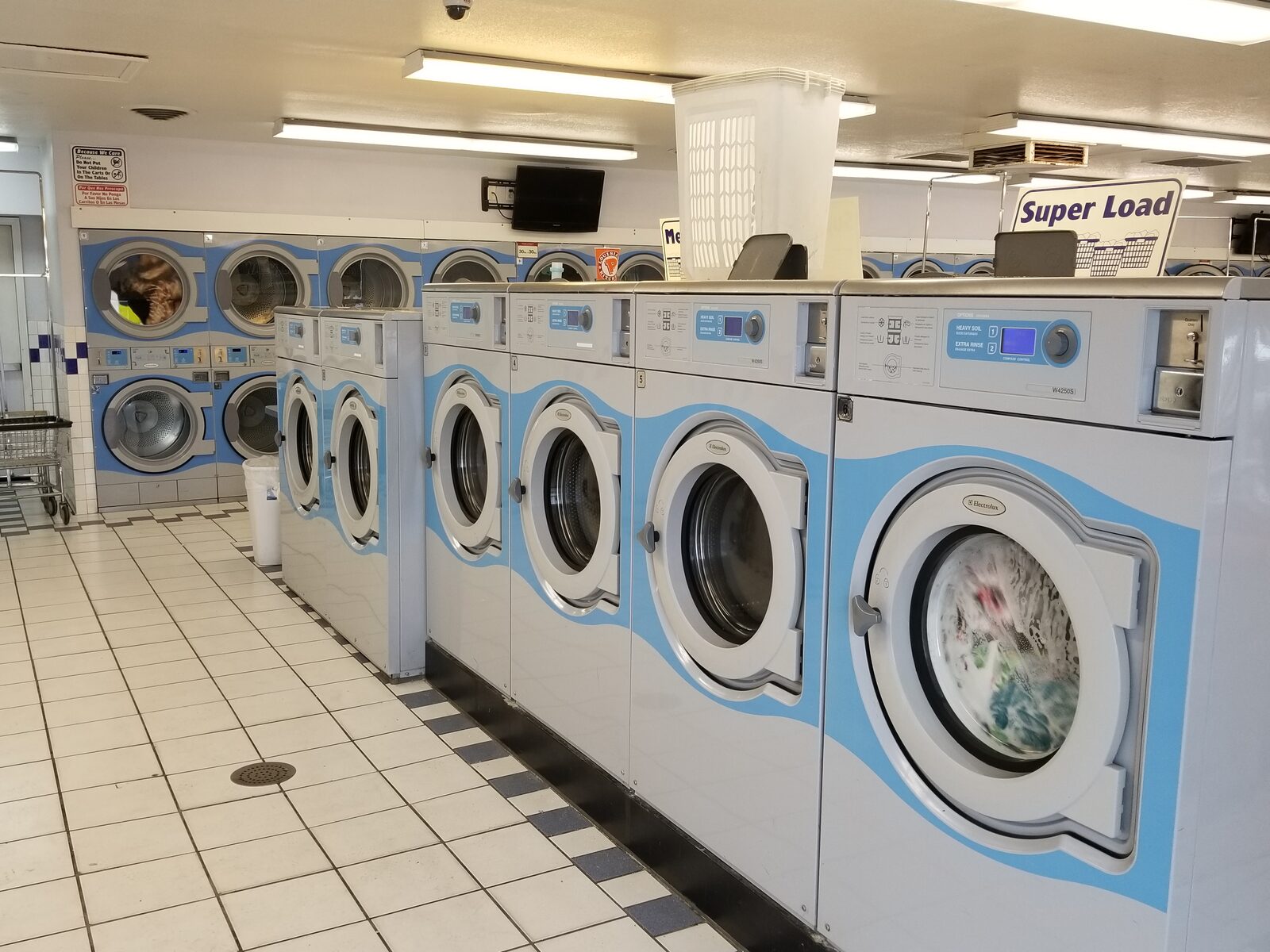 Rows of laundry machines inside Wash'em Up Laundry #4 - Laundromat Aurora